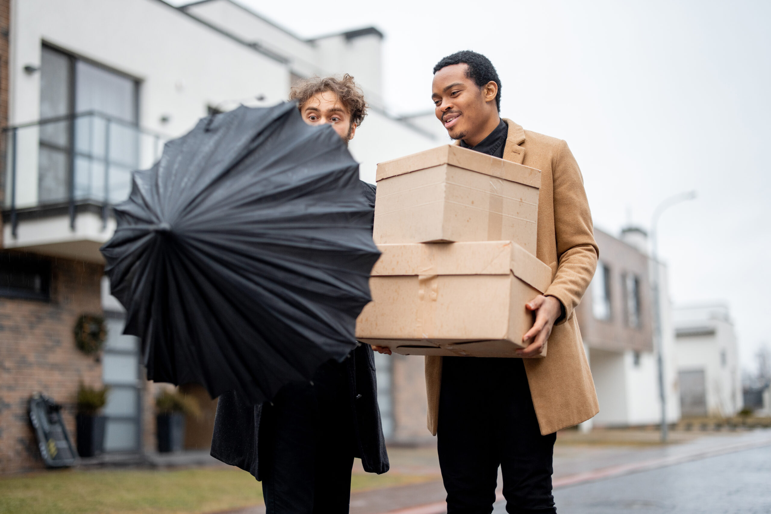 Gay couple walking together with parcels outdoors